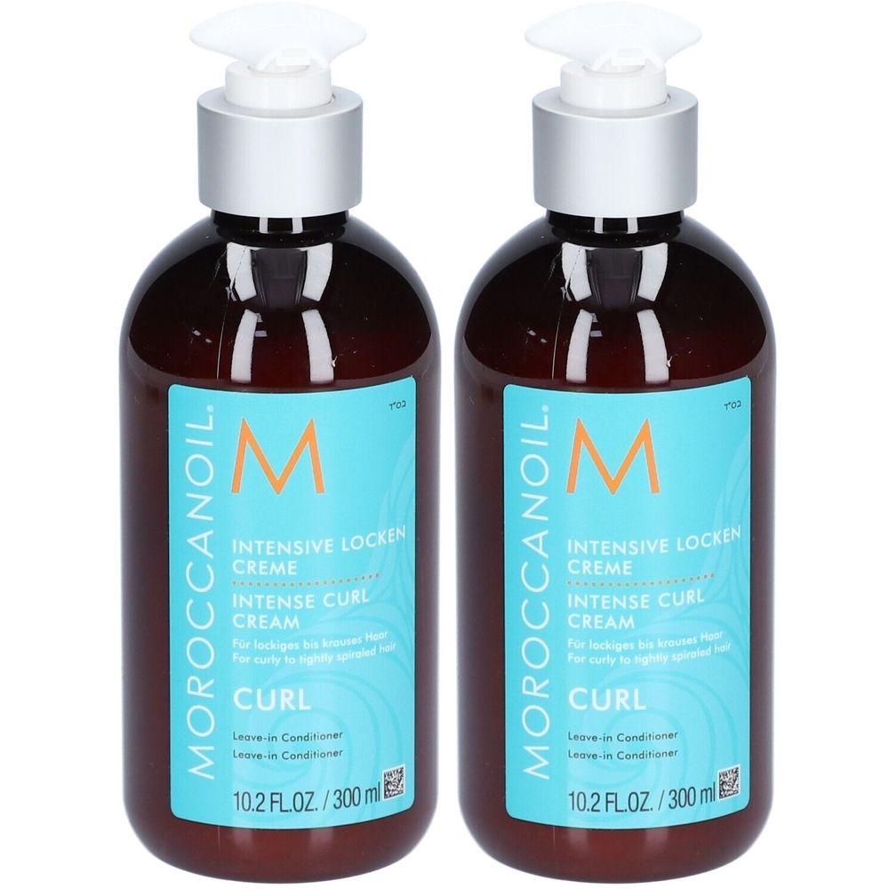 Deux flacons de crème Moroccanoil pour boucles. Flacons bruns avec étiquette bleue et pompe blanche. Texte : Crème boucles intensives.