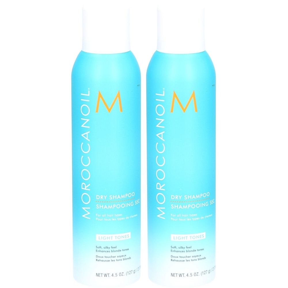 Deux flacons bleus avec bouchon blanc. Inscription: Moroccanoil, Dry Shampoo, Light Tones. Contenu net: 4.5 oz (127 g).