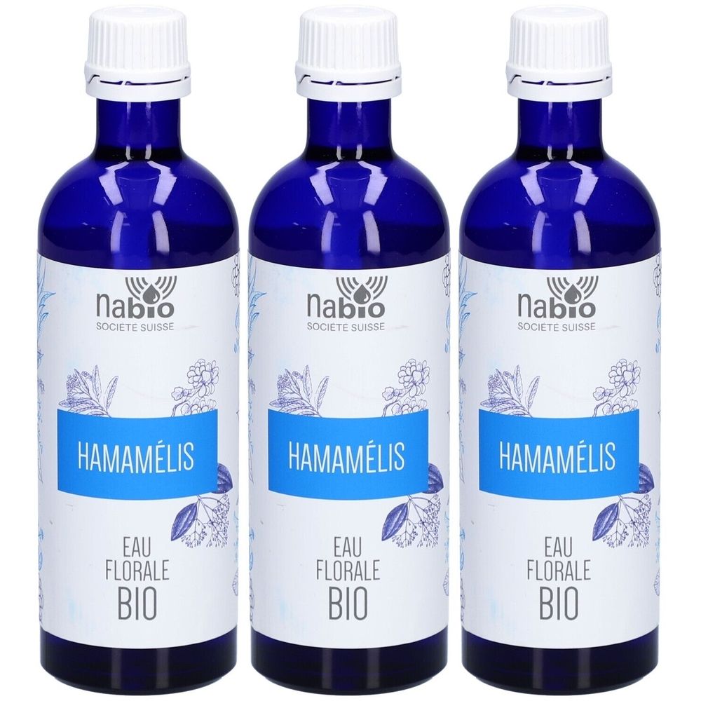 Trois flacons en verre bleu avec bouchons blancs. Étiquettes : "Nabio", "Hamamélis", "Eau Florale Bio".