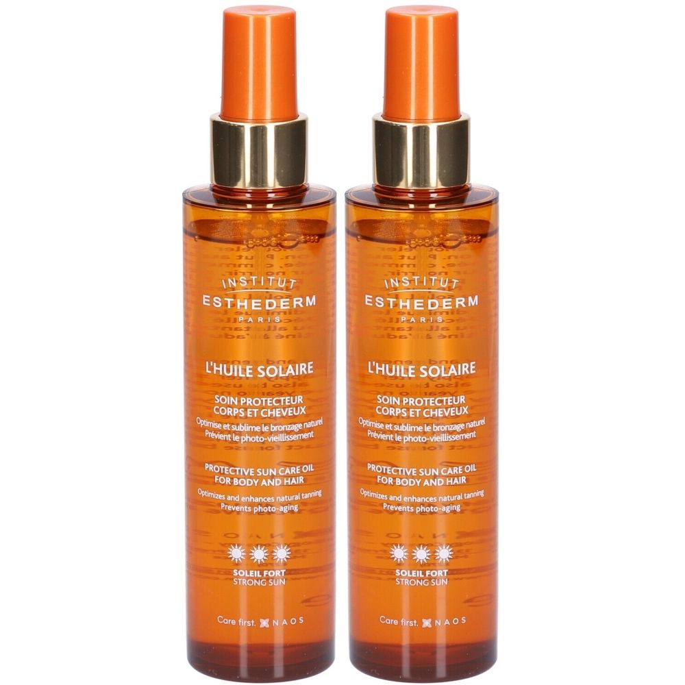 Zwei Flaschen Sonnenöl. Orangefarbene Sprühköpfe, goldfarbene Kragen. Aufschrift: INSTITUT ESTHEDERM, L'HUILE SOLAIRE, SOIN PROTECTEUR CORPS ET CHEVEUX.