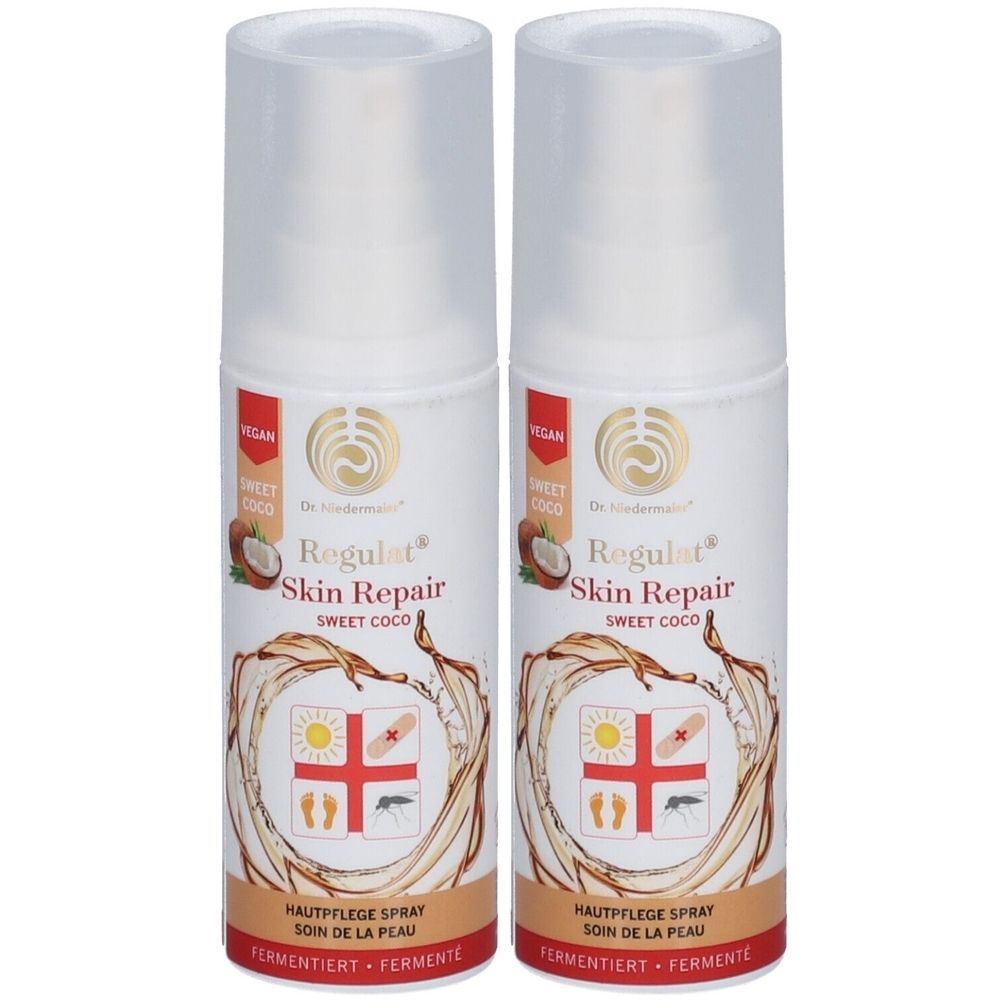 Zwei weiße Sprühflaschen mit Aufschrift Regulat Skin Repair. Vegan-Logo und Kokosnuss-Abbildung.