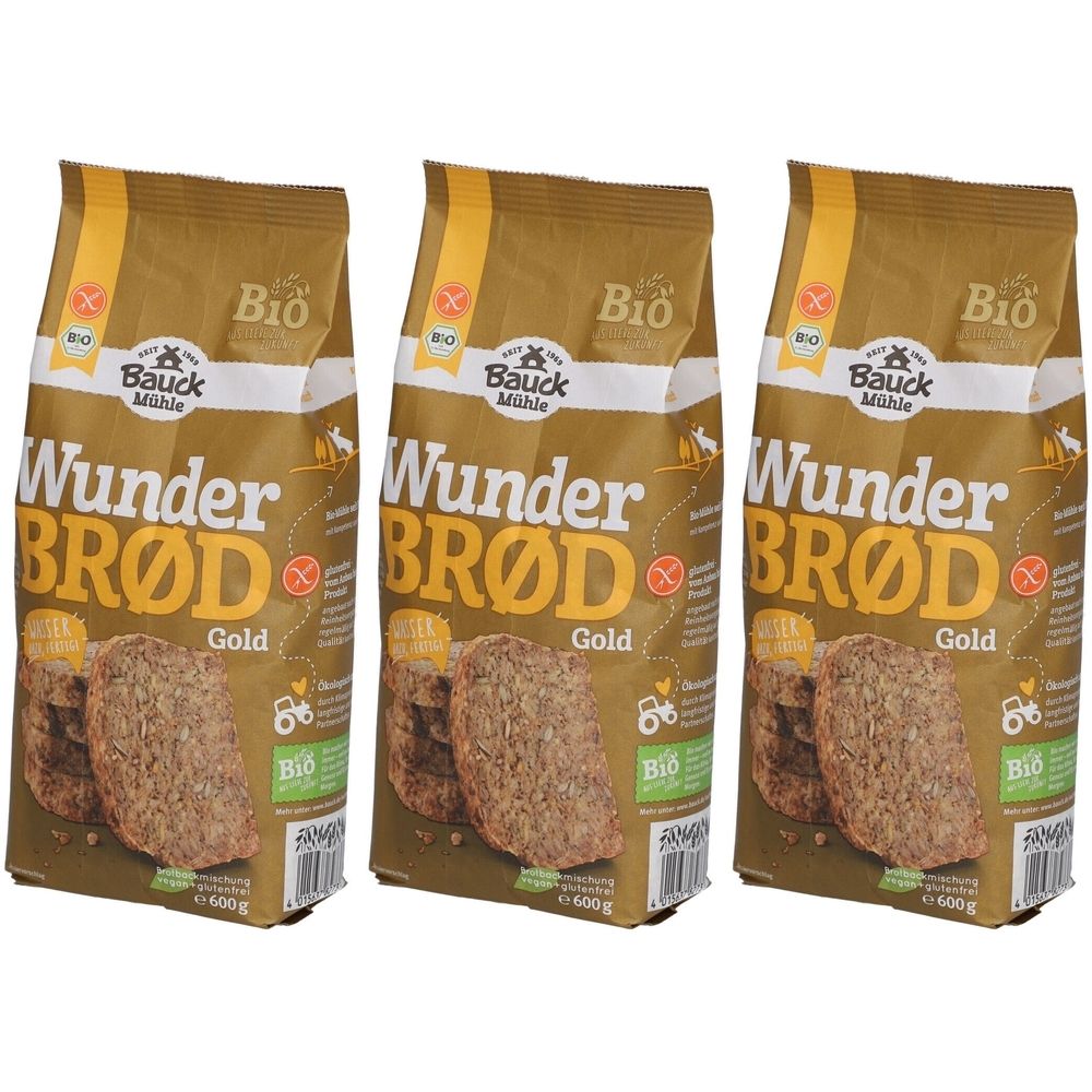 Drei Packungen Bauckhof Wunderbrod Gold Bio. Goldfarbene Verpackung mit Produktname und Bio-Siegel. Brotlaibe abgebildet.