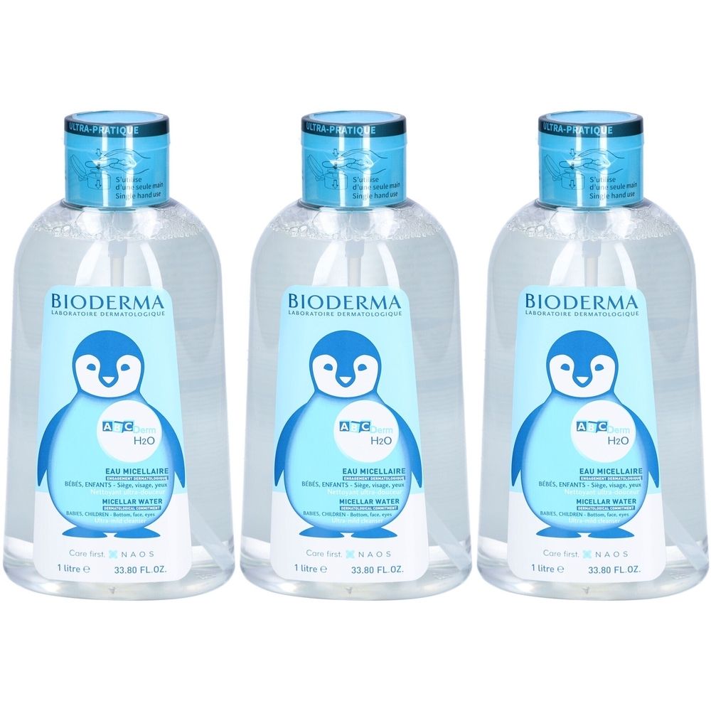 Drei Flaschen BIODERMA ABCDerm H2O Mizellenwasser. Klare Flüssigkeit in durchsichtigen Flaschen mit blauem Deckel und Etikett mit Pinguin-Motiv.