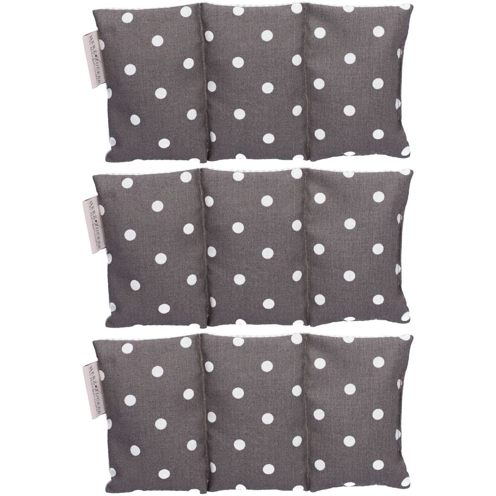 Coussin chauffant gris à pois blancs. Plusieurs compartiments. Étiquette avec texte.