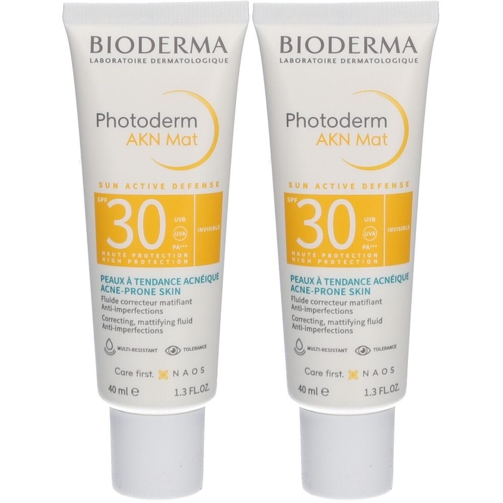 Zwei Tuben BIODERMA Photoderm AKN Mat SPF30. Weiße Tuben mit gelben Etiketten. Text: SUN ACTIVE DEFENSE, 30, PEAUX À TENDANCE ACNEIQUE.