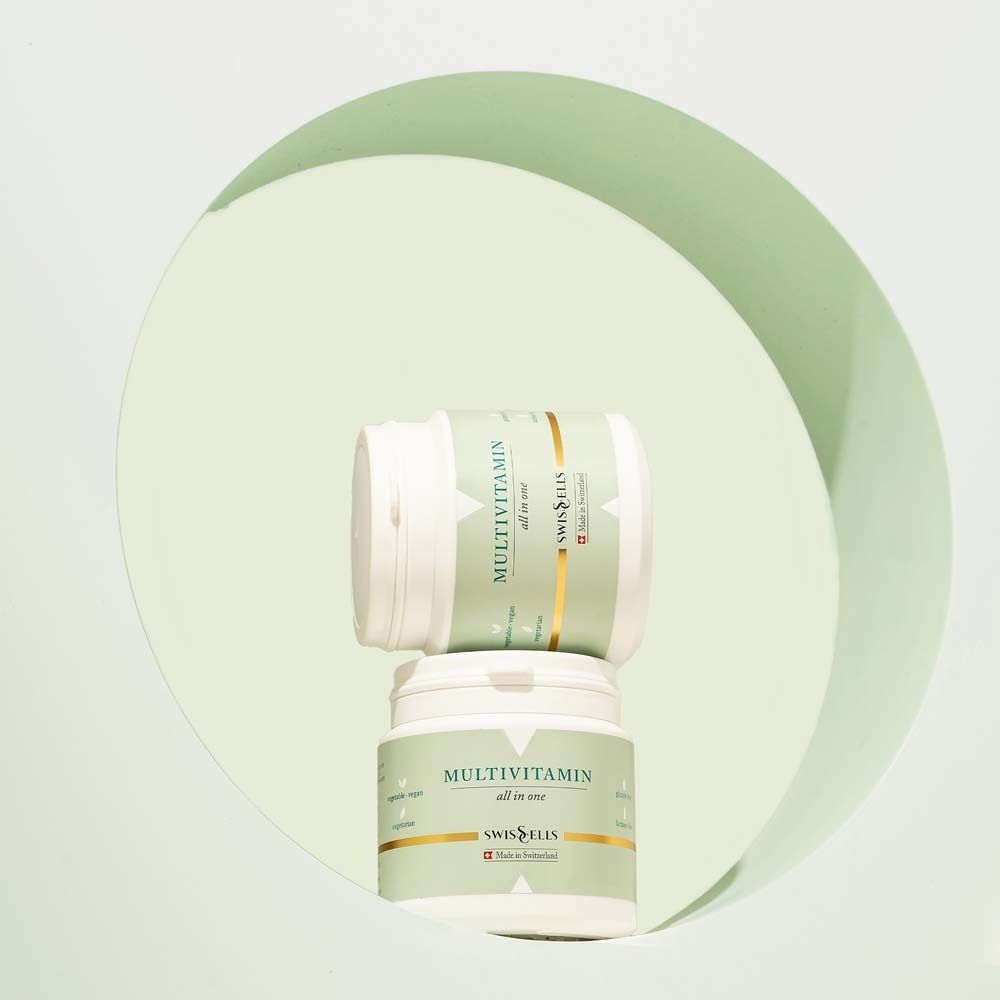 Zwei Dosen MULTIVITAMIN all in one. Weiße Dosen mit grünem Etikett. Marke: Swisscells. Made in Switzerland.