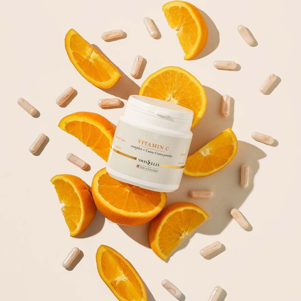 Produktglas mit Kapseln und Orangenscheiben. Aufschrift: Vitamin C complex + Camu-Camu powder. Marke: Swisscells.