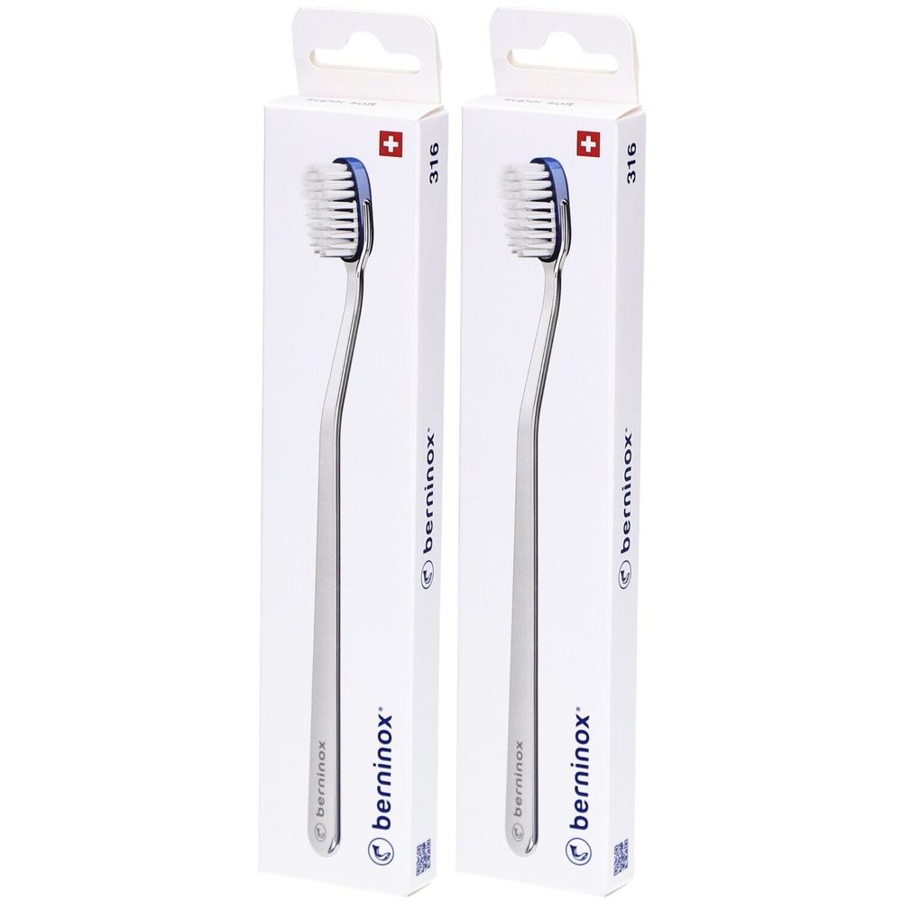 Deux brosses à dents dans des emballages blancs. Les brosses ont des poils bleus et des manches argentés. Croix suisse sur l'emballage.