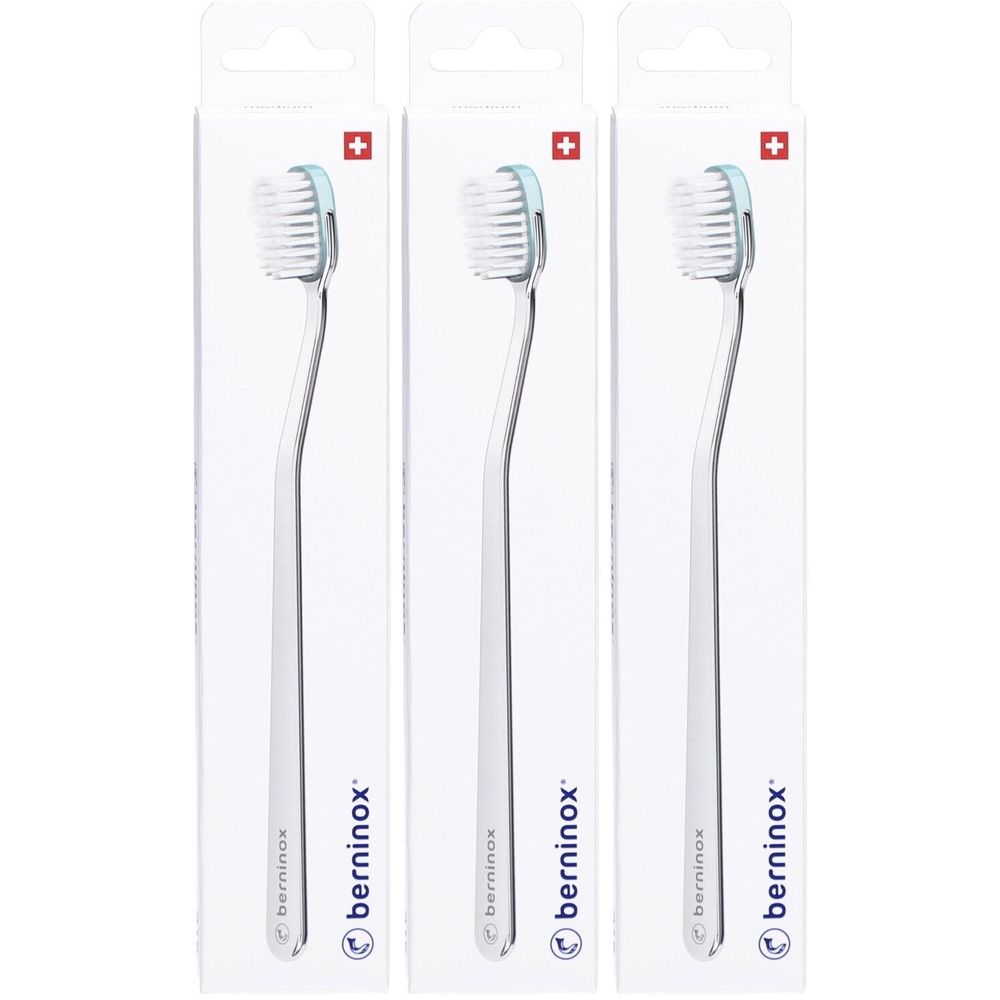 Drei Zahnbürsten in Verpackung. Weiße Borsten, hellblauer Bürstenkopf, transparenter Griff. Marke: berninox. Schweizer Kreuz.