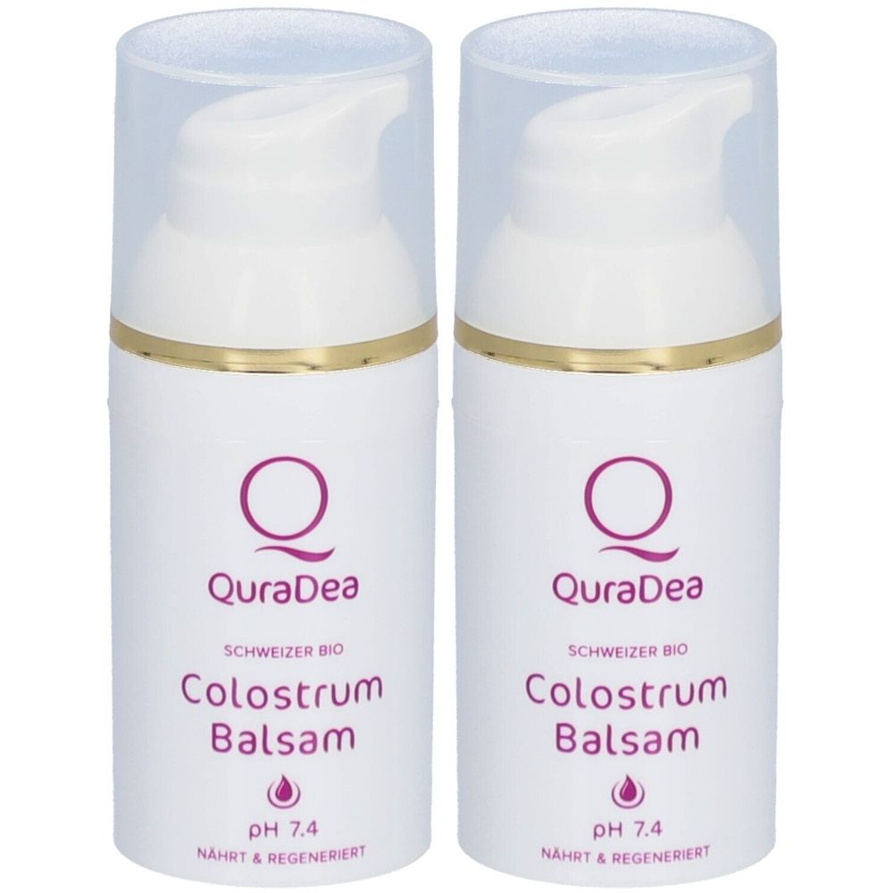 Zwei weiße Spenderflaschen mit transparentem Deckel. Aufschrift: QuraDea Colostrum Balsam, pH 7.4. Goldfarbener Ring.