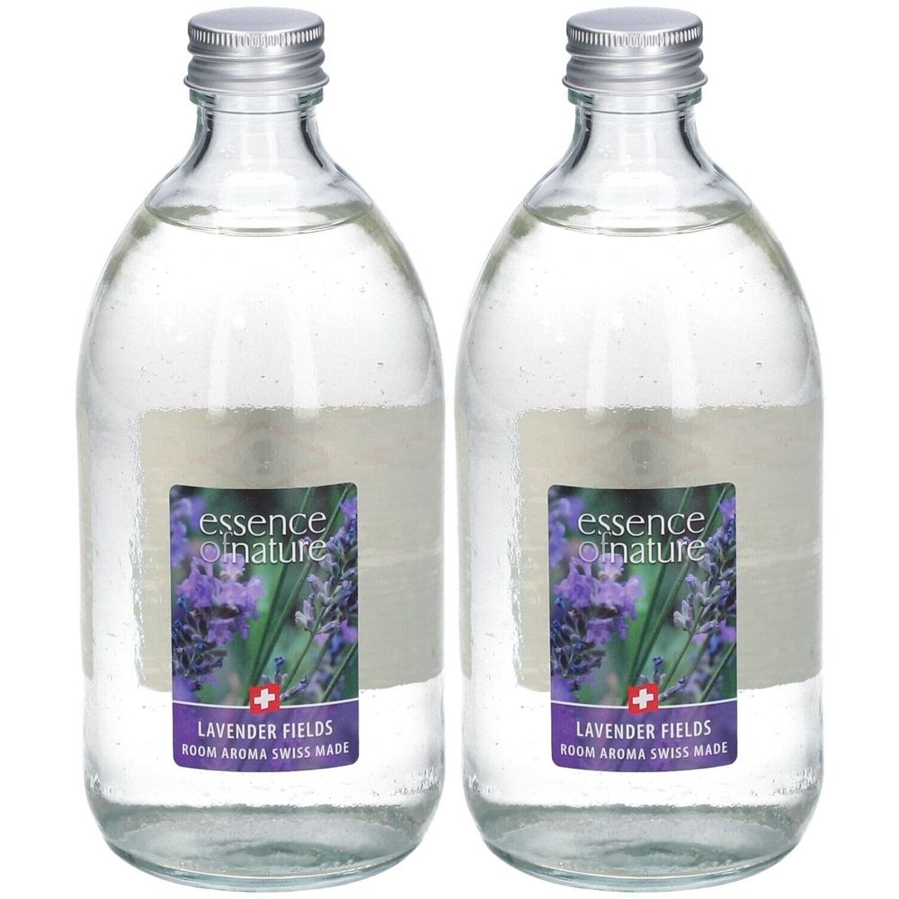Zwei Glasflaschen mit silbernen Verschlüssen. Etiketten zeigen Lavendelblüten und Text: essence nature, Lavender Fields, Room Aroma Swiss Made.