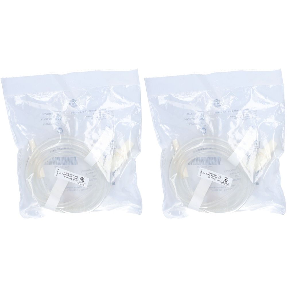 Zwei transparente Schläuche in Plastikverpackung. Aufkleber mit Text. Gelbliche Anschlüsse an den Enden.
