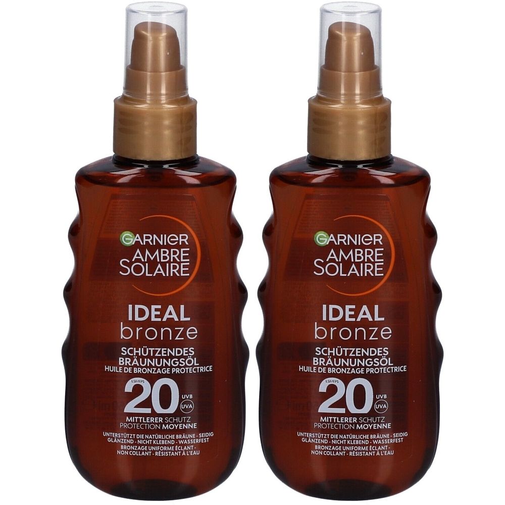 Zwei Flaschen Garnier Ambre Solaire. Braune Flüssigkeit in braunen Flaschen mit Sprühkopf. Aufschrift: Ideal Bronze, SPF 20.