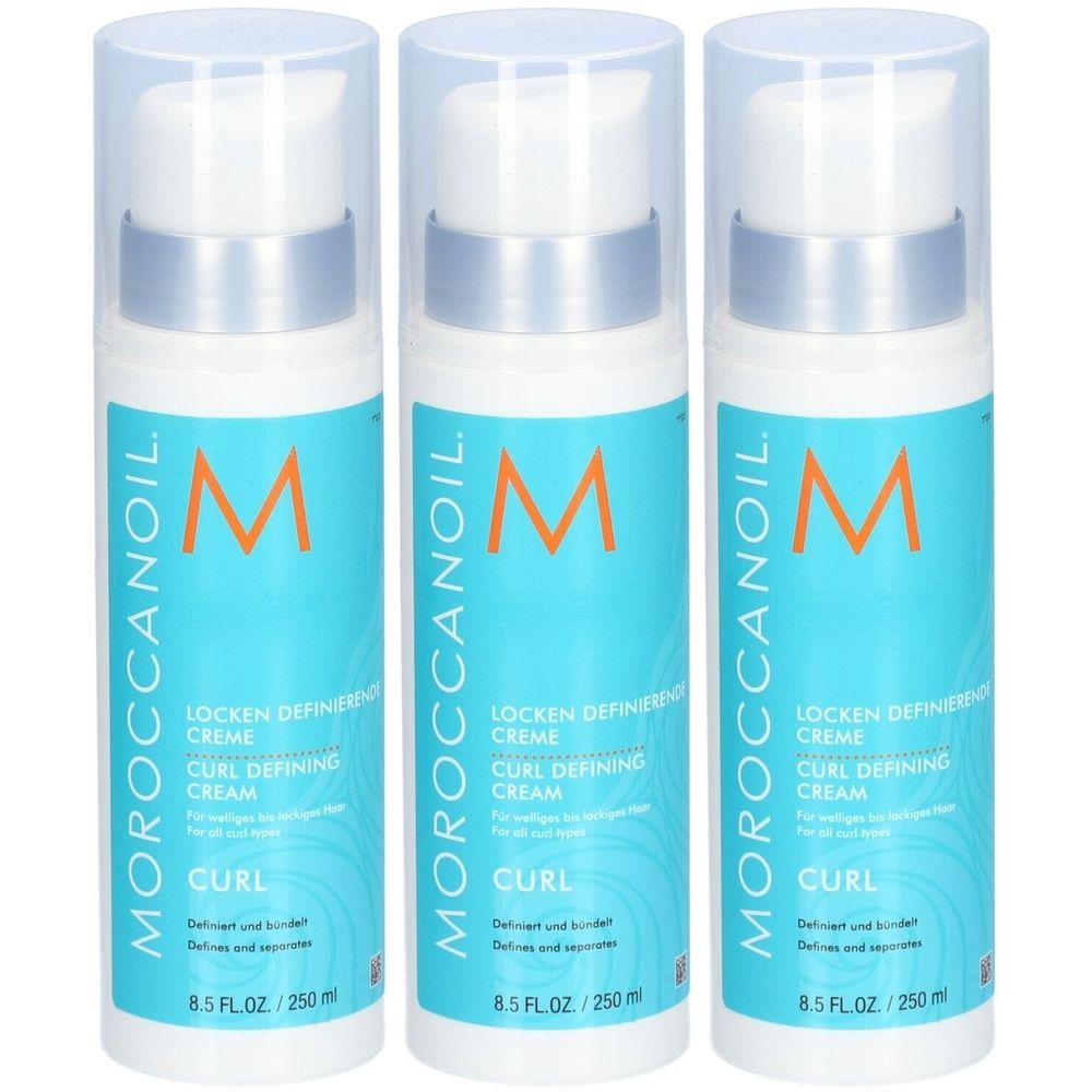 Drei Flaschen Moroccanoil Locken modellierende Creme. Weiße Flaschen mit blauem Etikett und orangefarbenem Logo. Text: Curl Defining Cream.