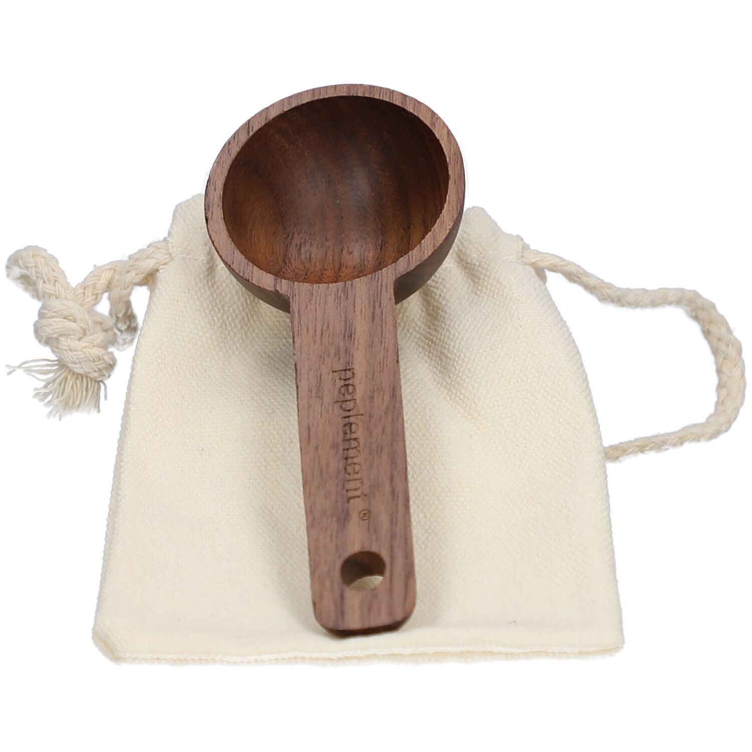 Holz-Messlöffel in einer beigen Stofftasche. Der Löffel hat einen langen Griff mit dem Markennamen. Der Löffel hat eine runde Form.