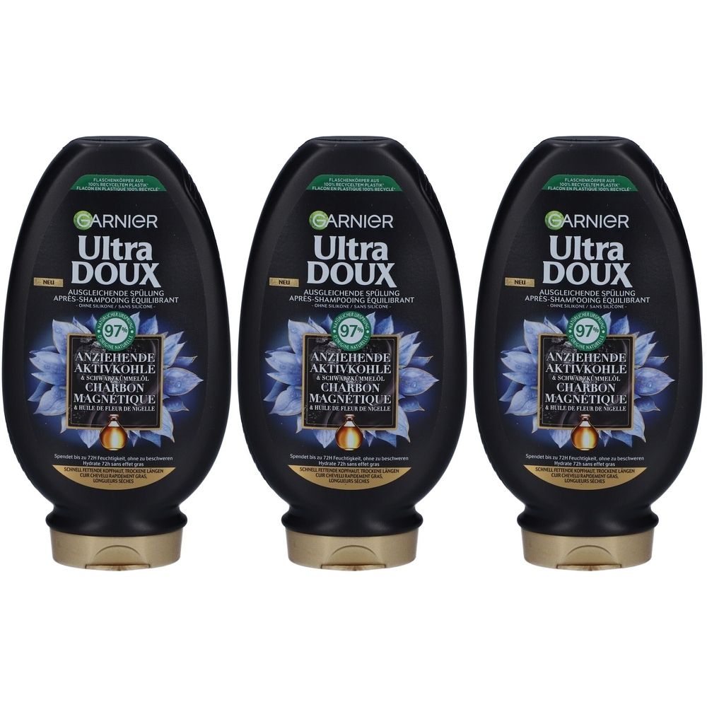 Trois flacons noirs avec des bouchons dorés. Chaque flacon porte l'inscription "GARNIER Ultra DOUX" et "ANZIEHENDE AKTIVKOHLE".