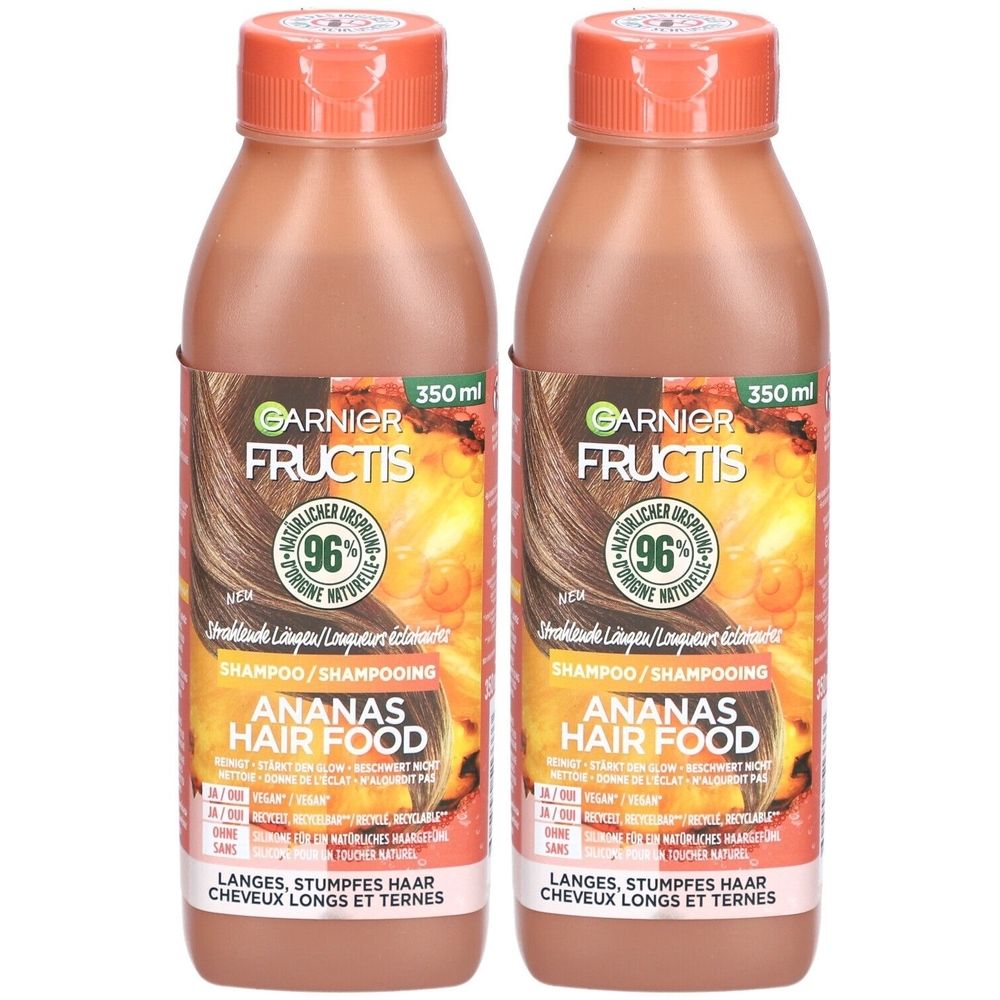 Zwei Flaschen Shampoo. Aufschrift: Garnier Fructis Ananas Hair Food. 350 ml. Orangefarbener Deckel. Braune Flüssigkeit.