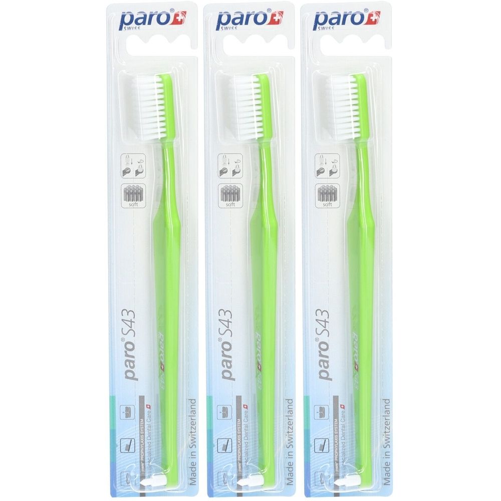 Drei Zahnbürsten in Verpackung. Grüne Griffe, weiße Borsten. Marke: paro S43. Hergestellt in der Schweiz.