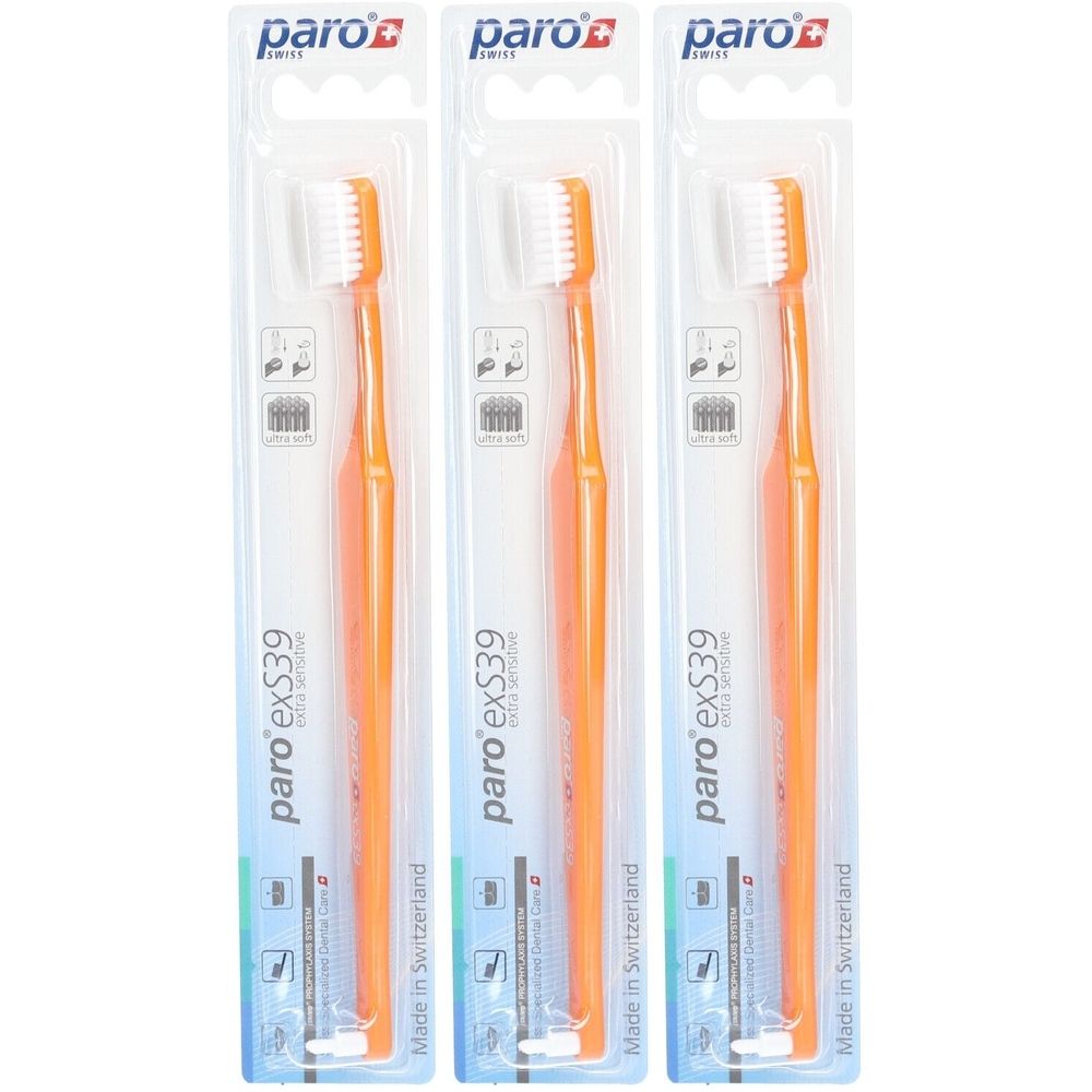 Drei Zahnbürsten in Blisterverpackung. Orangefarbene Griffe, weiße Borsten. Marke: paro exS39. Hergestellt in der Schweiz.