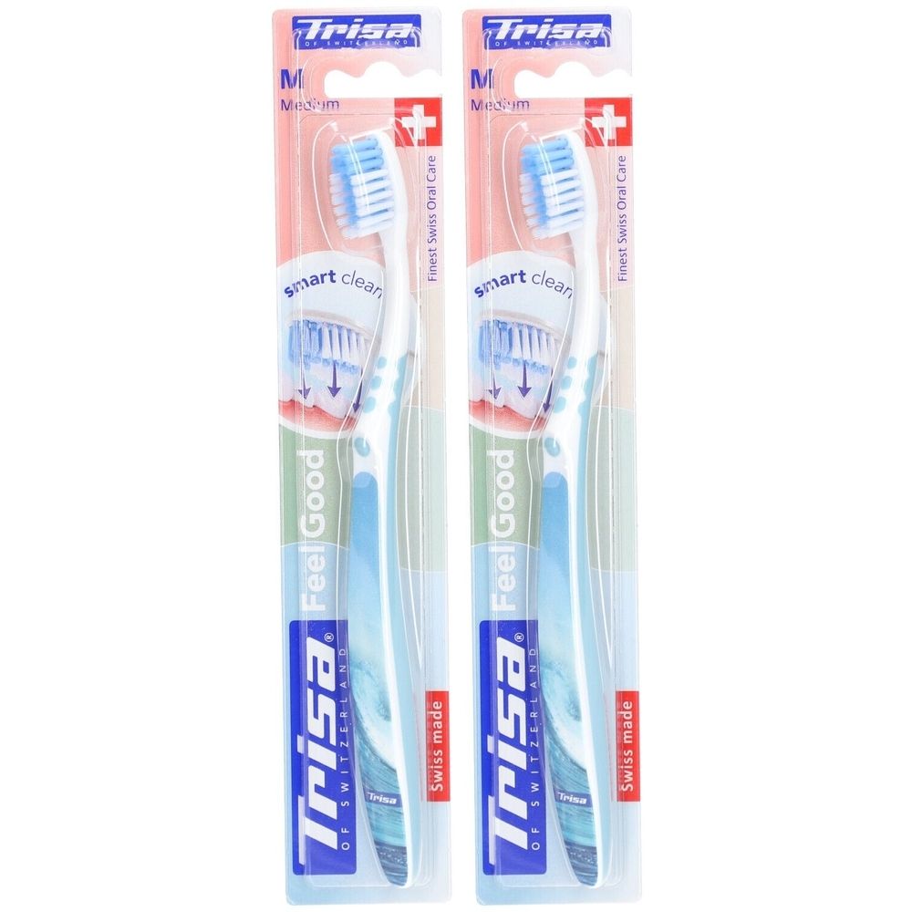 Deux brosses à dents emballées. Soies bleues, manche blanc. Marque Trisa. Inscription Feel Good, Swiss made.
