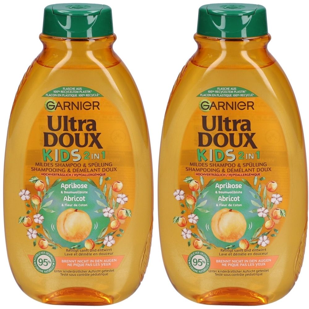 Zwei Flaschen Shampoo. Aufschrift: GARNIER Ultra DOUX KIDS 2in1. Mit Aprikose und Baumwollblüte. Grüner Deckel, orangefarbene Flüssigkeit.