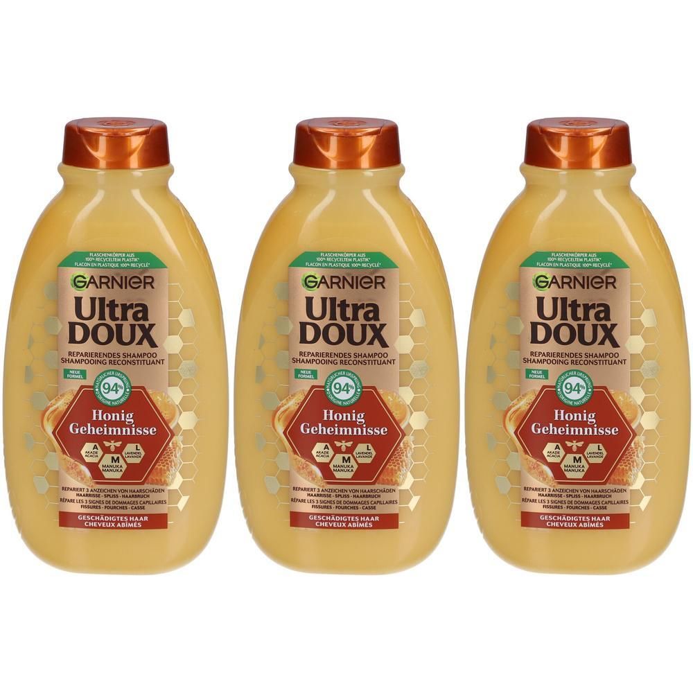 Trois bouteilles de shampooing. Sur chaque bouteille : GARNIER Ultra DOUX, Honig Geheimnisse. Bouteilles jaunes avec bouchons bruns.