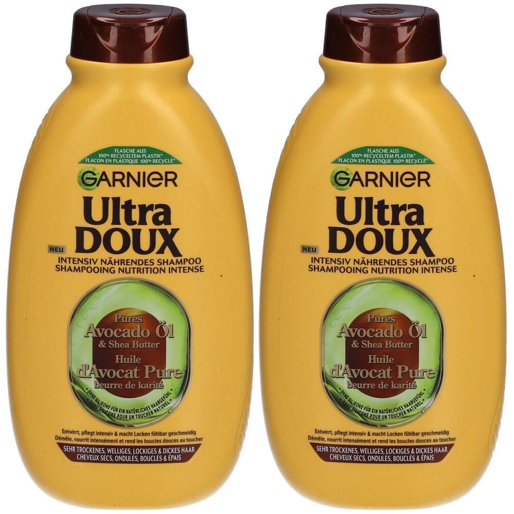 Deux flacons jaunes de shampooing Garnier Ultra Doux. Huile d'avocat et beurre de karité. Bouchon marron, étiquettes vertes.