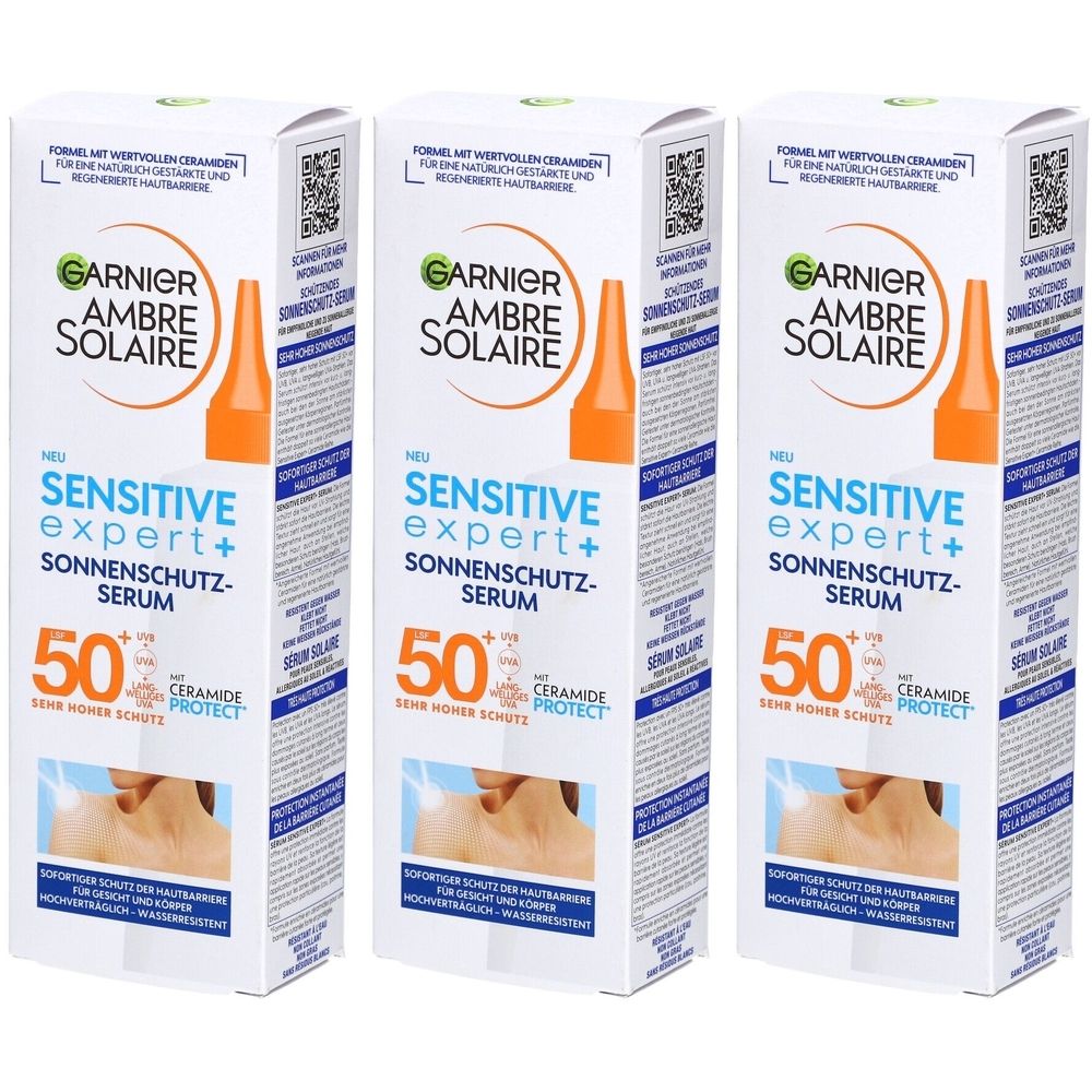 Drei Kartons Garnier Ambre Solaire Sensitive Expert+ Sonnenschutz-Serum SPF50+. Weiße Verpackung mit Produktabbildung und Text.