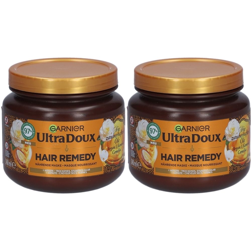 Zwei braune Tiegel mit goldenen Deckeln. Auf den Etiketten steht Garnier Ultra Doux Hair Remedy. Aufschrift: Argan- und Kamelienöl.