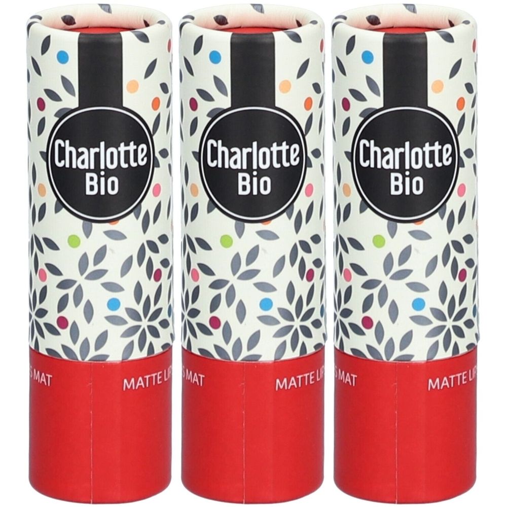 Drei Lippenstift-Verpackungen. Zylinderförmig, mit floralem Muster und dem Logo Charlotte Bio. Roter Boden, schwarzer Streifen.