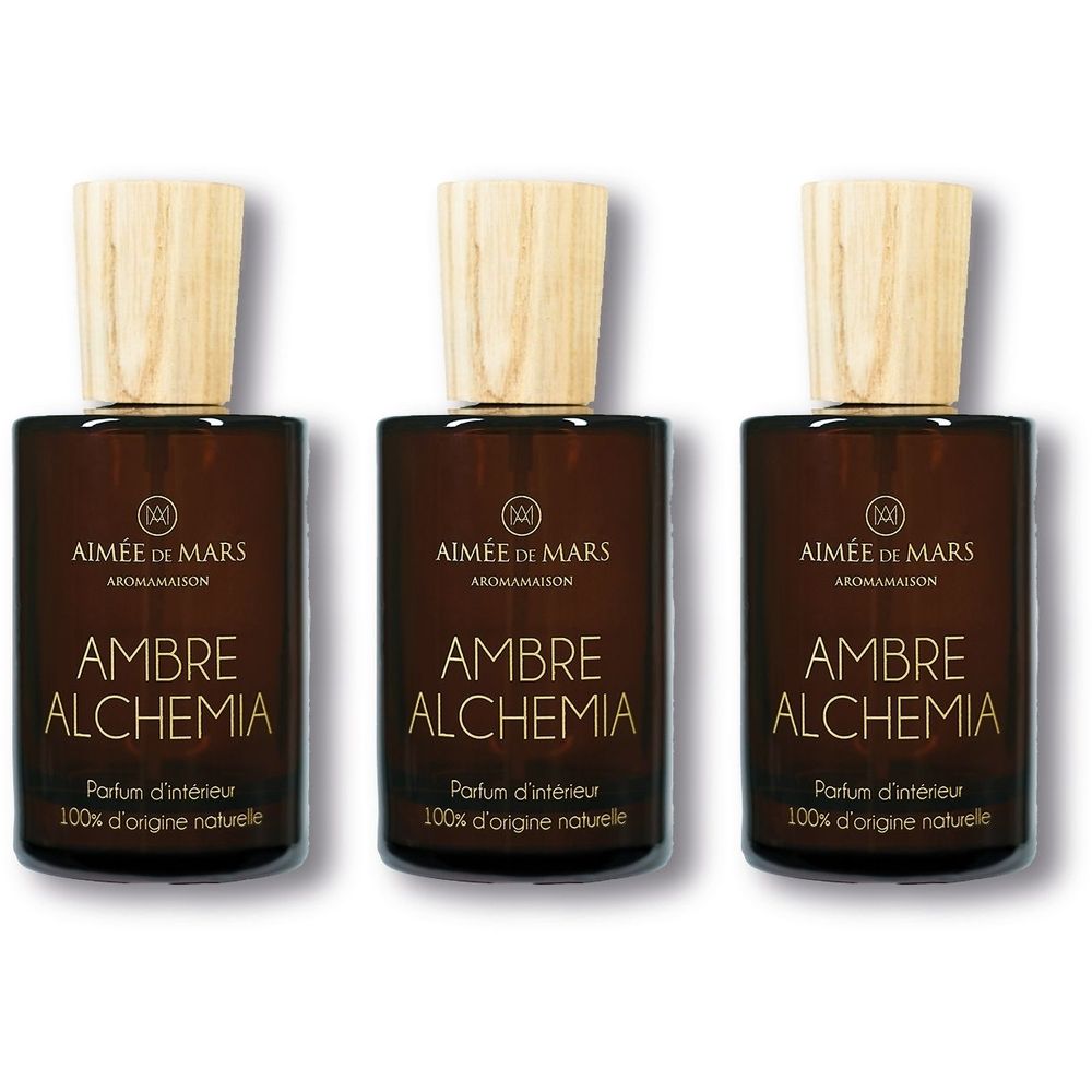 Trois flacons en verre brun avec bouchons en bois. Inscription: AMBRE ALCHEMIA, Parfum d'intérieur, 100% d'origine naturelle. Marque: AIMÉE DE MARS.