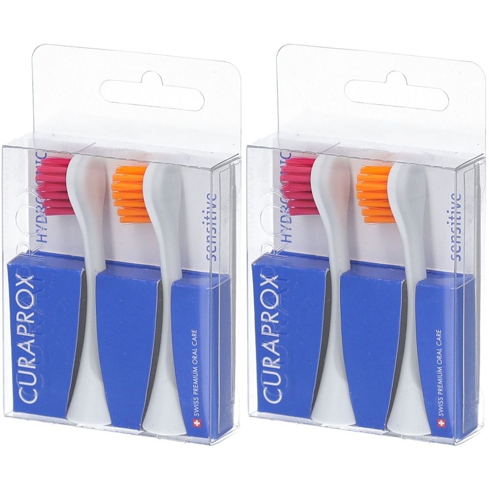 Zwei Packungen mit je zwei Zahnbürstenköpfen. Blaue Basis, transparente Verpackung. Rosa und orange Borsten. Schriftzug: CURAPROX, sensitive.