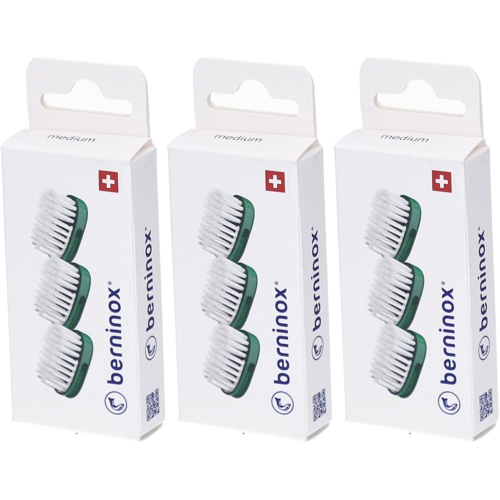 Trois boîtes de rechange pour têtes de brosse. Chaque boîte montre trois têtes de brosse avec des poils blancs et des supports verts. Croix suisse.