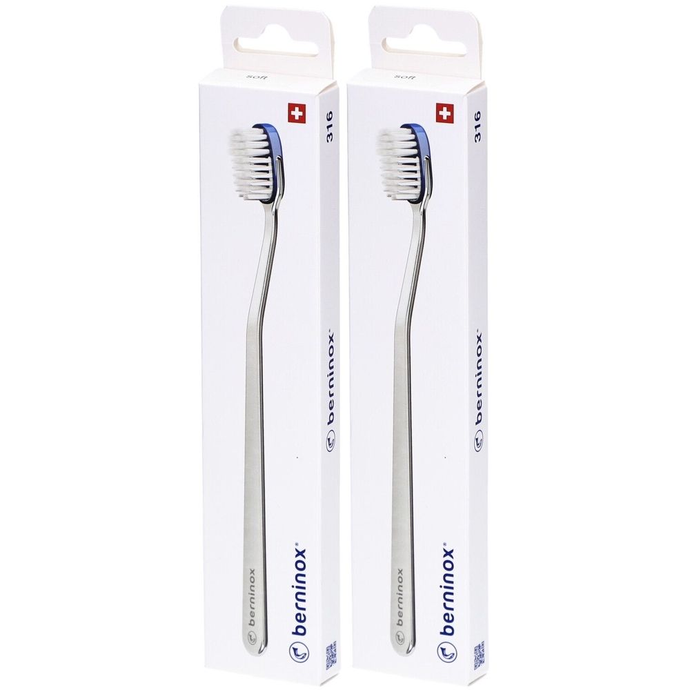 Deux brosses à dents dans leur emballage. Tête de brosse blanche, bord bleu, manche argenté. Emballage avec logo et croix suisse.