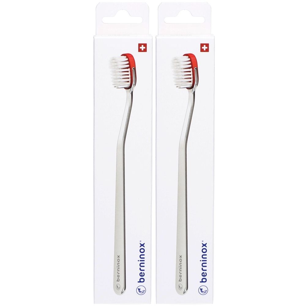 Deux brosses à dents dans un emballage blanc. Tête rouge, manche argenté. Marque : berninox. Croix suisse.