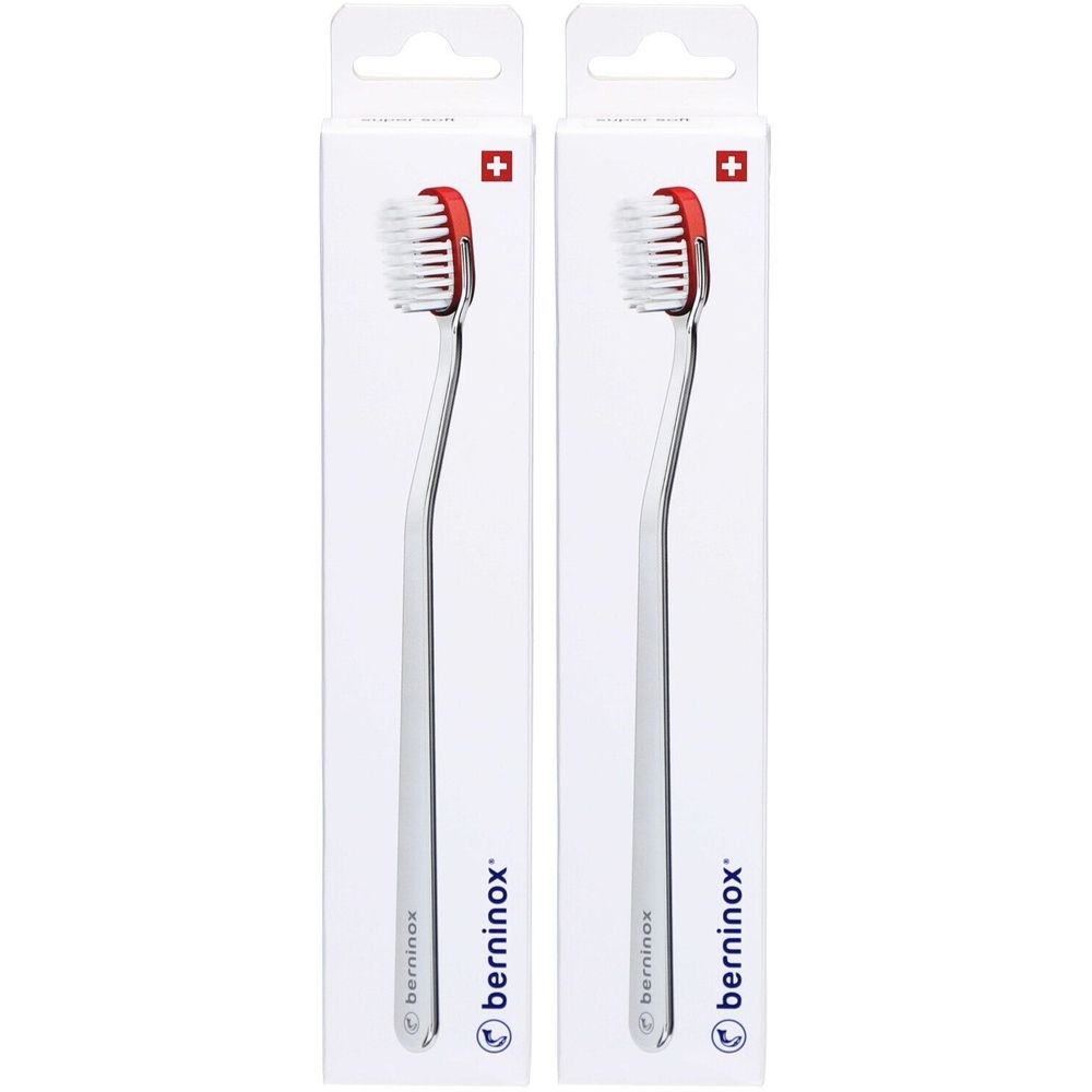 Deux brosses à dents emballées. Soies blanches, tête rouge, manche argenté. Marque: berninox. Croix suisse.