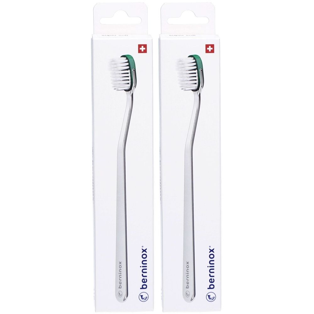 Deux brosses à dents dans leur emballage. Accents verts sur la tête. Croix suisse en haut à droite. Marque : berninox.