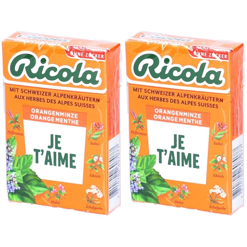 Deux boîtes de bonbons Ricola Orange menthe. Emballage orange avec texte et illustrations d'herbes. Texte: Je t'aime.
