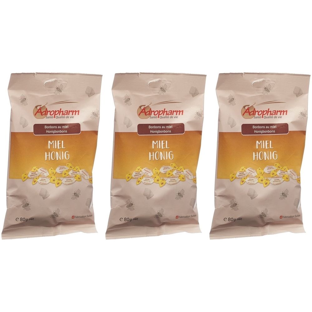 Trois sachets de bonbons au miel. Inscription: Adropharm, Miel Honig. Emballage avec un design jaune et marron.
