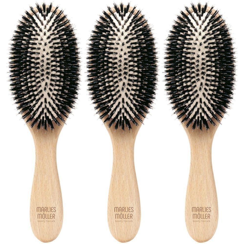 Trois brosses à cheveux ovales avec manche en bois. Soies noires sur fond clair. "Marlies Möller beauty haircare" est inscrit sur le manche.