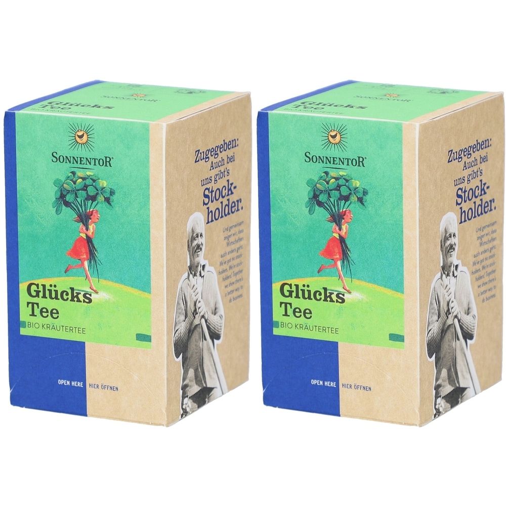 Zwei rechteckige Kartons mit Aufdruck. Aufschrift: Sonnentor Glückstee. Abbildung einer Frau mit Kleeblättern. Grün, blau, beige.