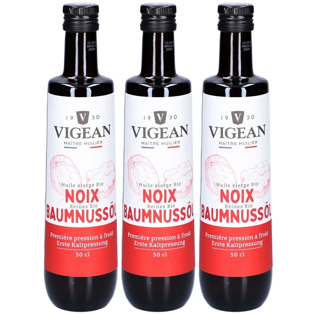 Trois bouteilles d'huile de noix Vigean Bio. Bouteilles noires avec étiquettes blanches et bande rouge. Inscription : NOIX, BAUMNUSSO, 50 cl.