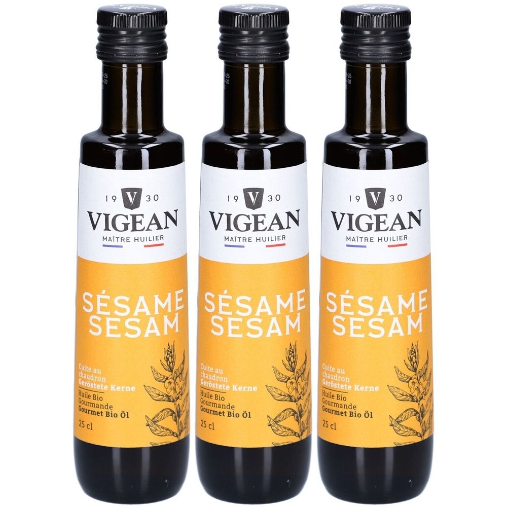 Trois bouteilles d'huile de sésame. Étiquette avec « VIGEAN » et « SÉSAME SESAM ». Bouchon noir, bouteille marron, étiquette jaune.