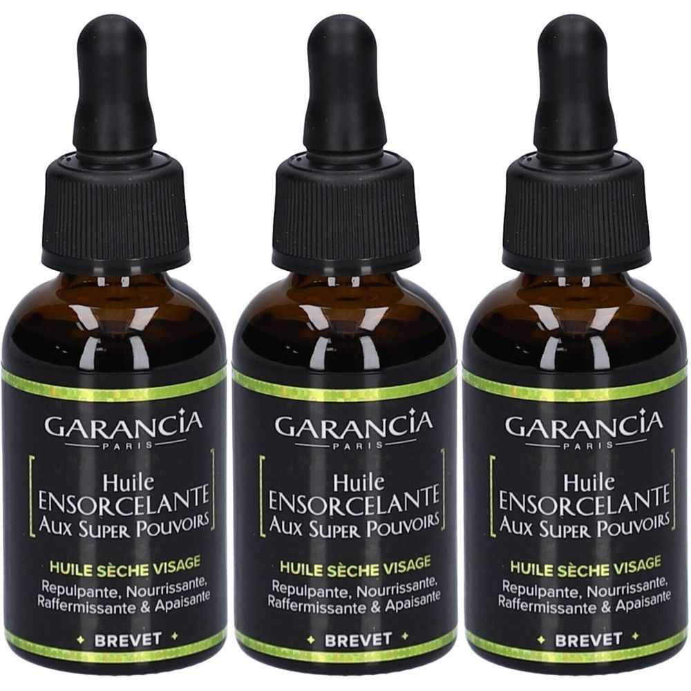Drei Flaschen Gesichtsöl mit schwarzem Deckel und Pipette. Aufschrift: GARANCIA PARIS, Huile Ensorcelante Aux Super Pouvoirs.