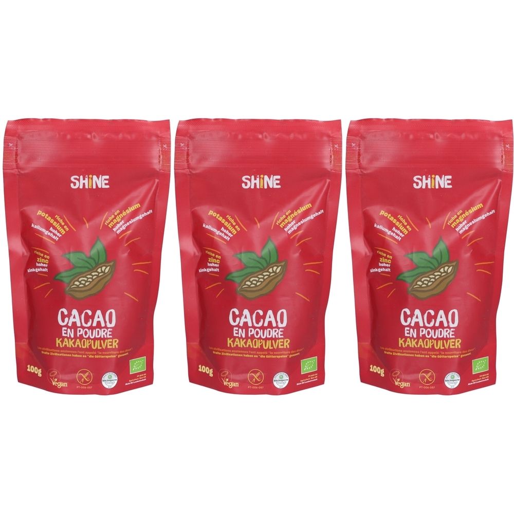 Drei rote Beutel mit Kakaopulver. Aufschrift: SHINE, CACAO EN POUDRE KAKAOPULVER. Mit Bio-Siegel und Vegan-Logo.