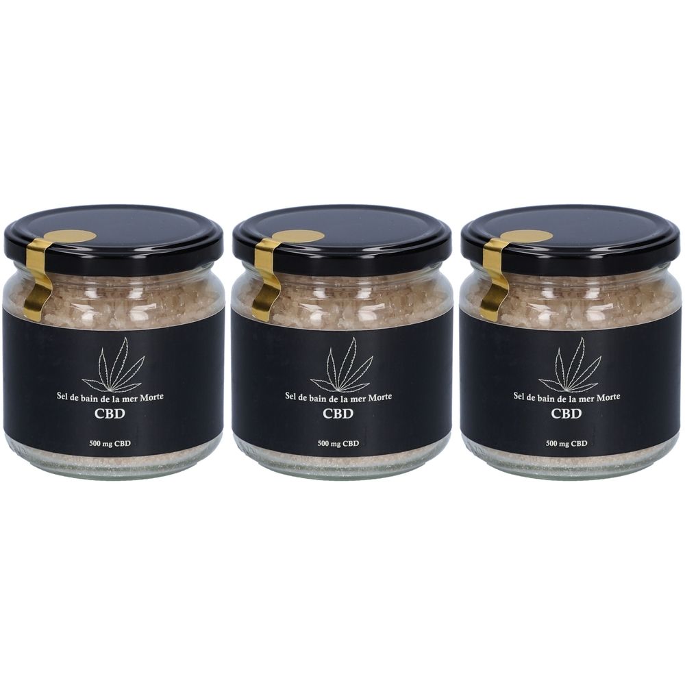 Trois pots de sel de bain de la mer Morte avec étiquette noire et couvercle doré. Inscription: CBD.
