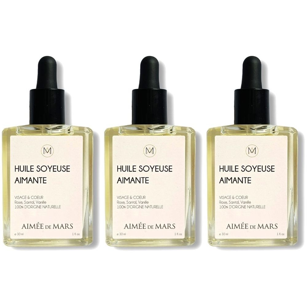 Trois flacons carrés en verre avec compte-gouttes noir. L'étiquette indique "HUILE SOYEUSE AIMANTE" et "AIMÉE DE MARS".