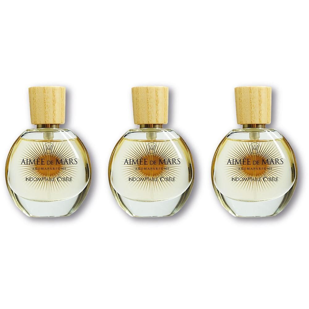 Trois flacons ronds en verre avec bouchon en bois, remplis de parfum clair.