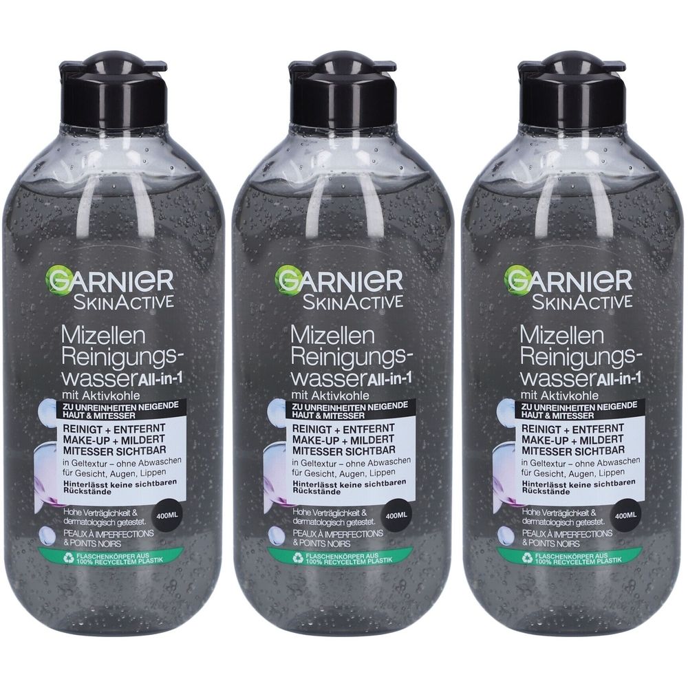 Trois flacons de Garnier Skinactive eau micellaire. Bouchons noirs, flacons transparents avec liquide noir. Texte sur l'étiquette.