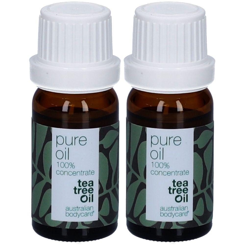 Deux petites bouteilles en verre brun avec bouchons blancs. Étiquettes : "pure oil 100% concentrate tea tree oil australian bodycare".